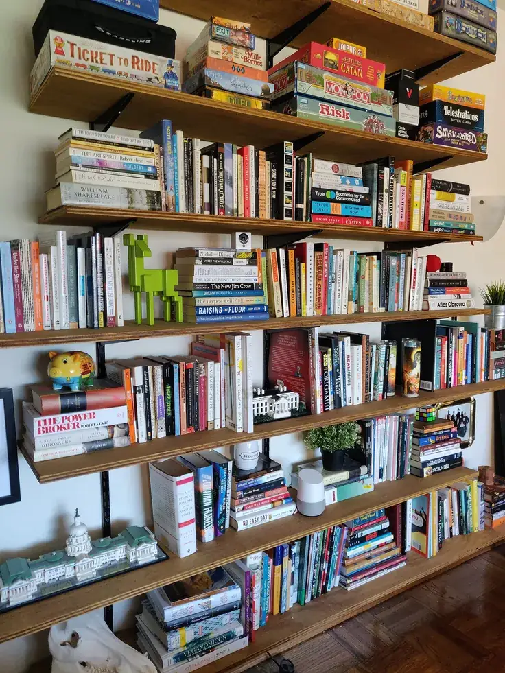 کتابخانه دیواری چوبی در منزل با کتاب‌های زیاد