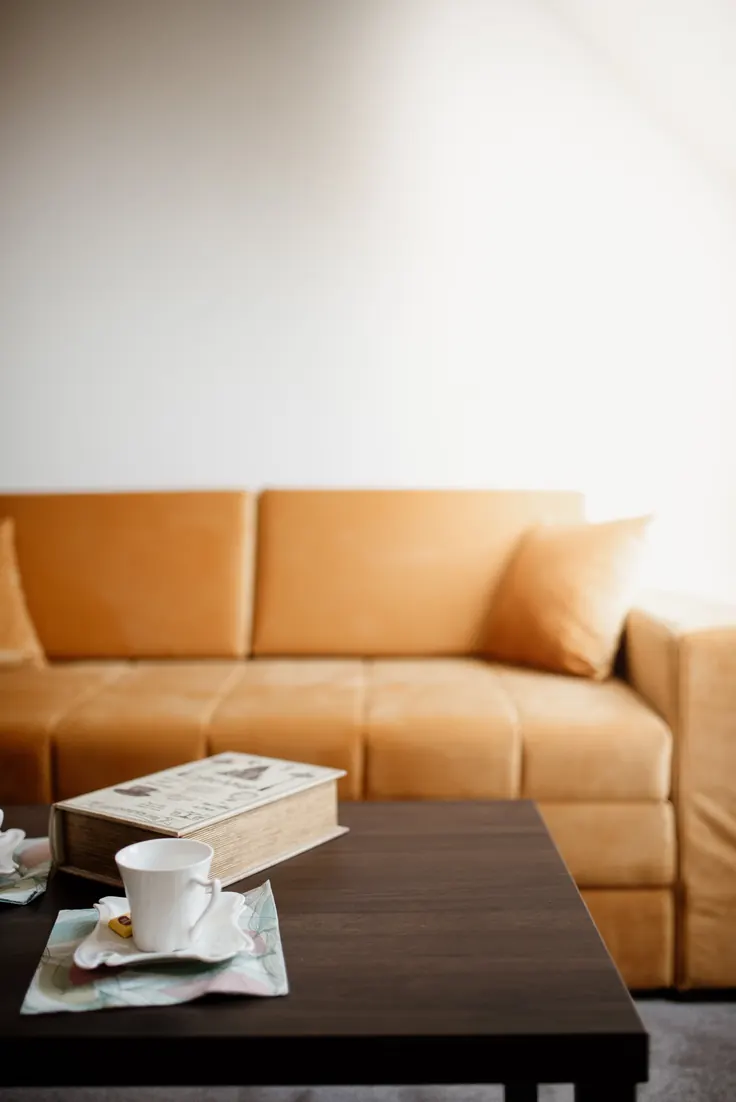 کتاب و فنجان چای روی صفحه چوب گردو